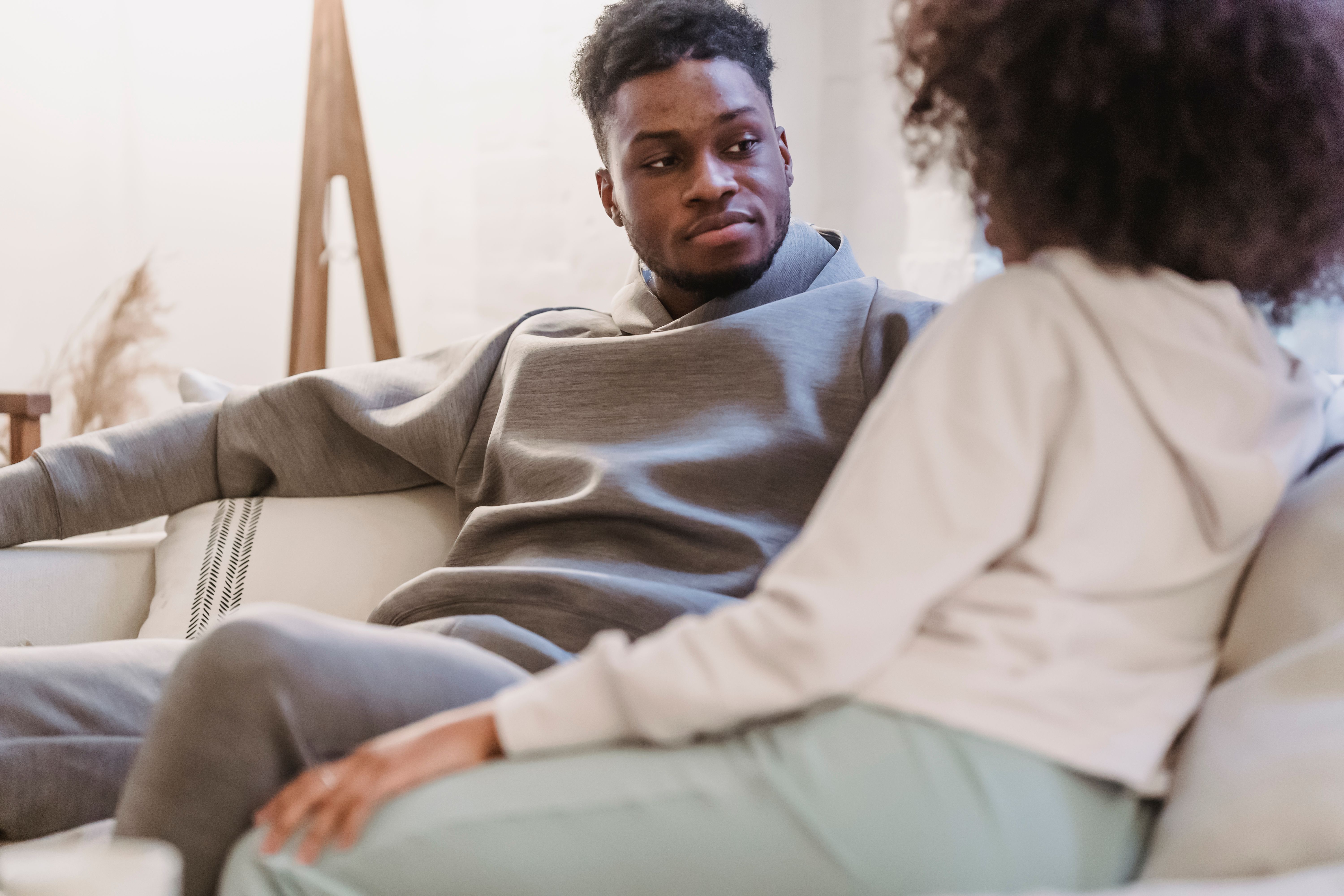 Partner listening attentively to a girlfriend on a sofa, representing open communication and consent in safe roleplay