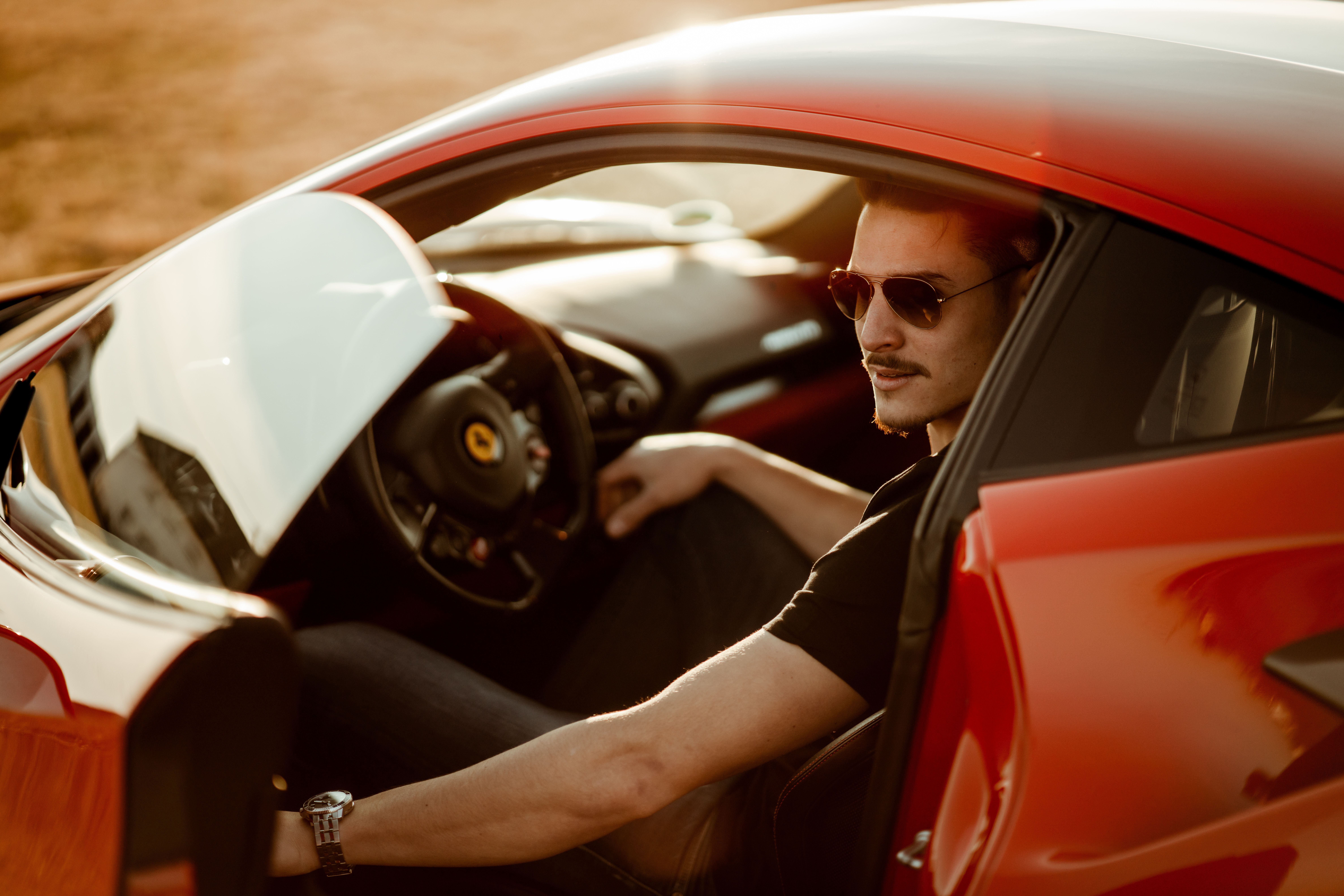 Stylish man seated in a luxurious red sports car, a symbol of the wealth and power driving the sugar daddy fantasy